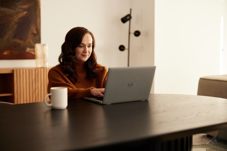 Woman sitting at a table using a laptop