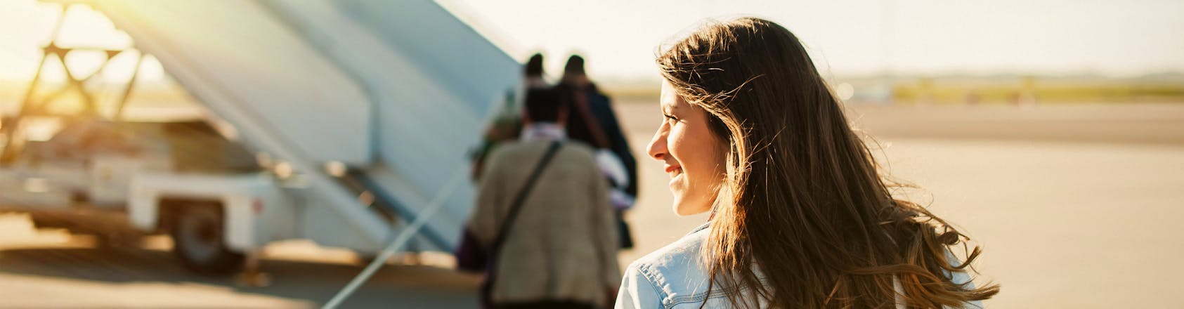 Woman walking across tarmac to board a plane