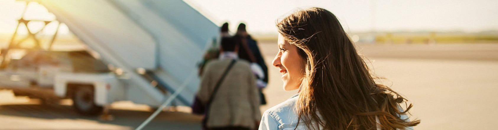 Woman walking across tarmac to board a plane