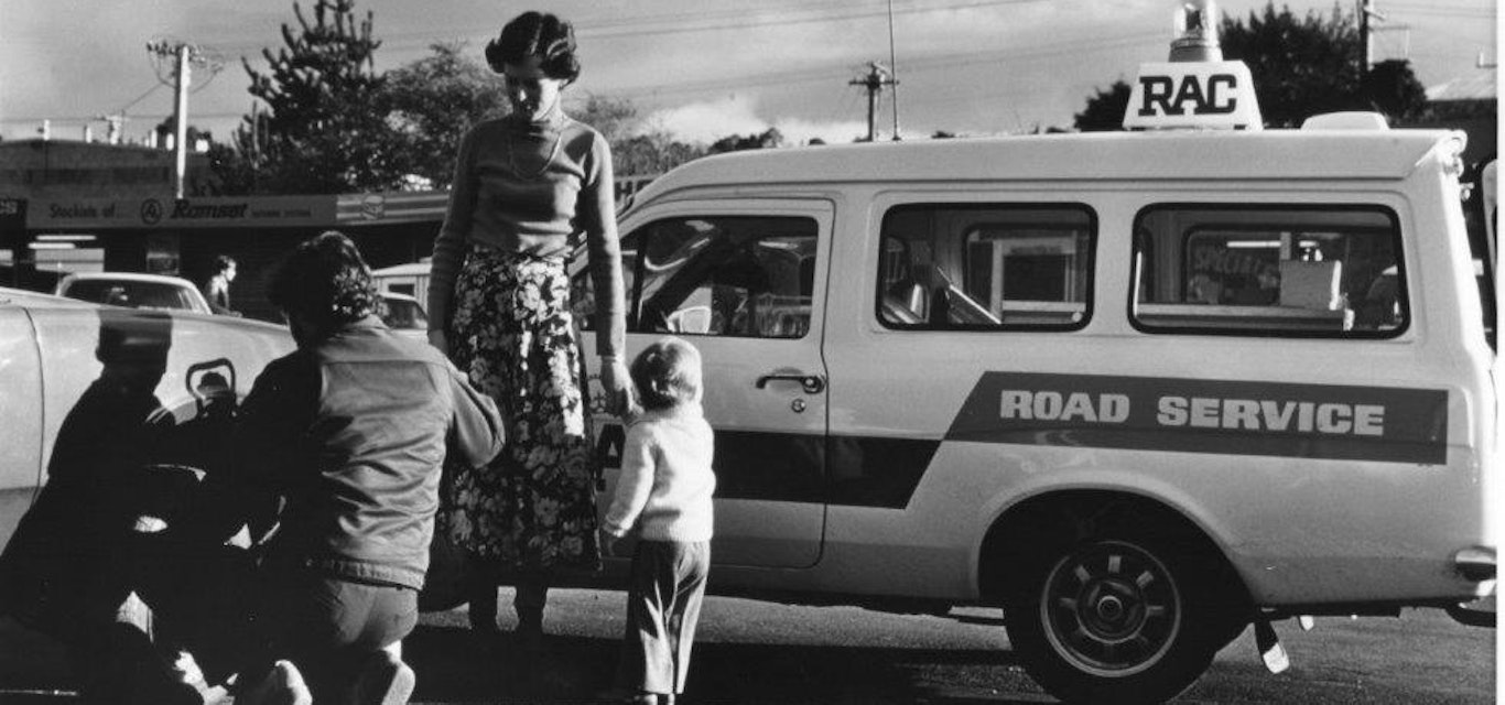 Family getting help on the side of the road in the early days.