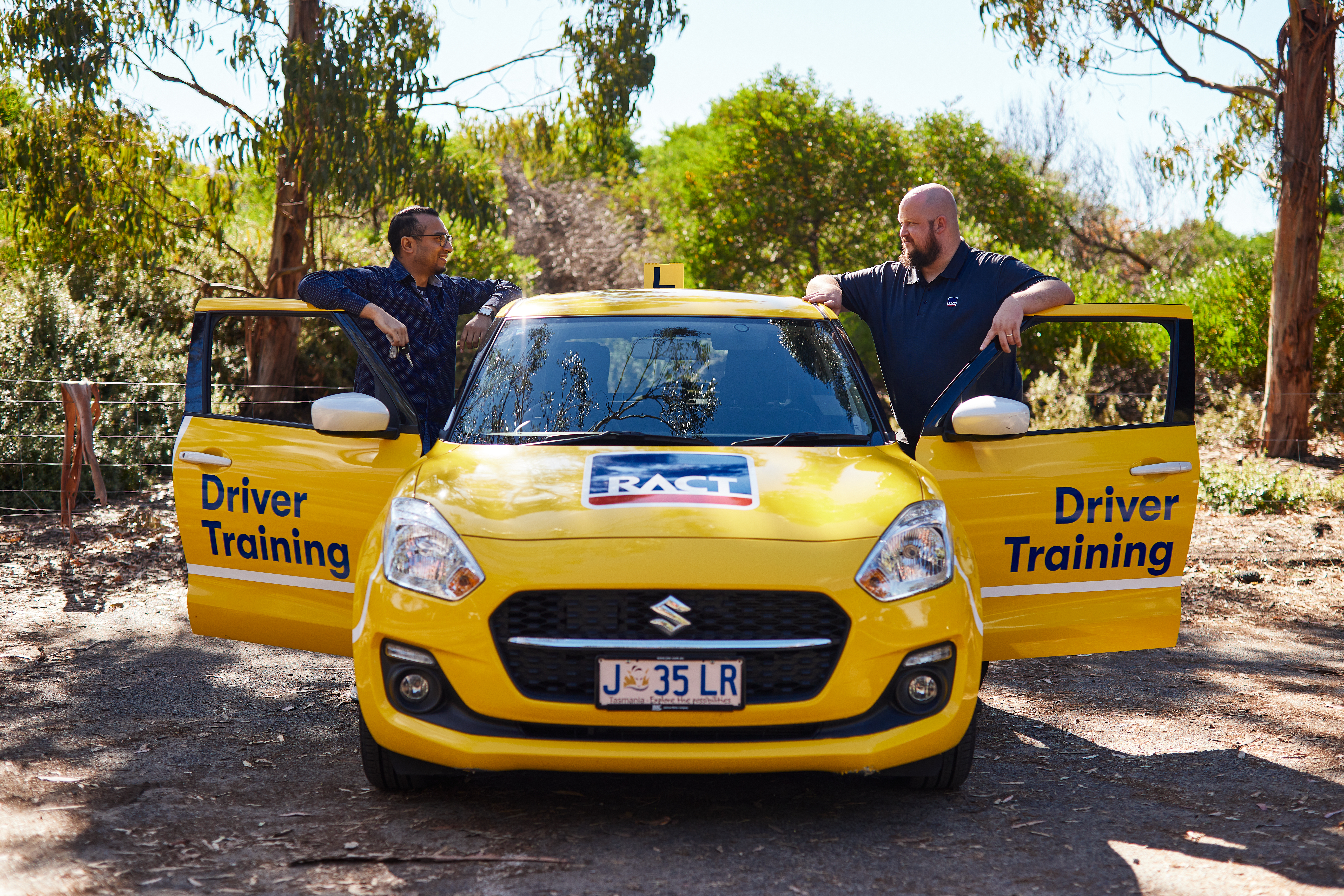 Learner driver and instructor standing near car