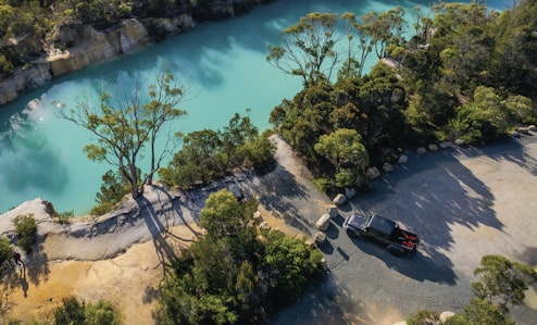 Jeep Gladiator next to little blue lake