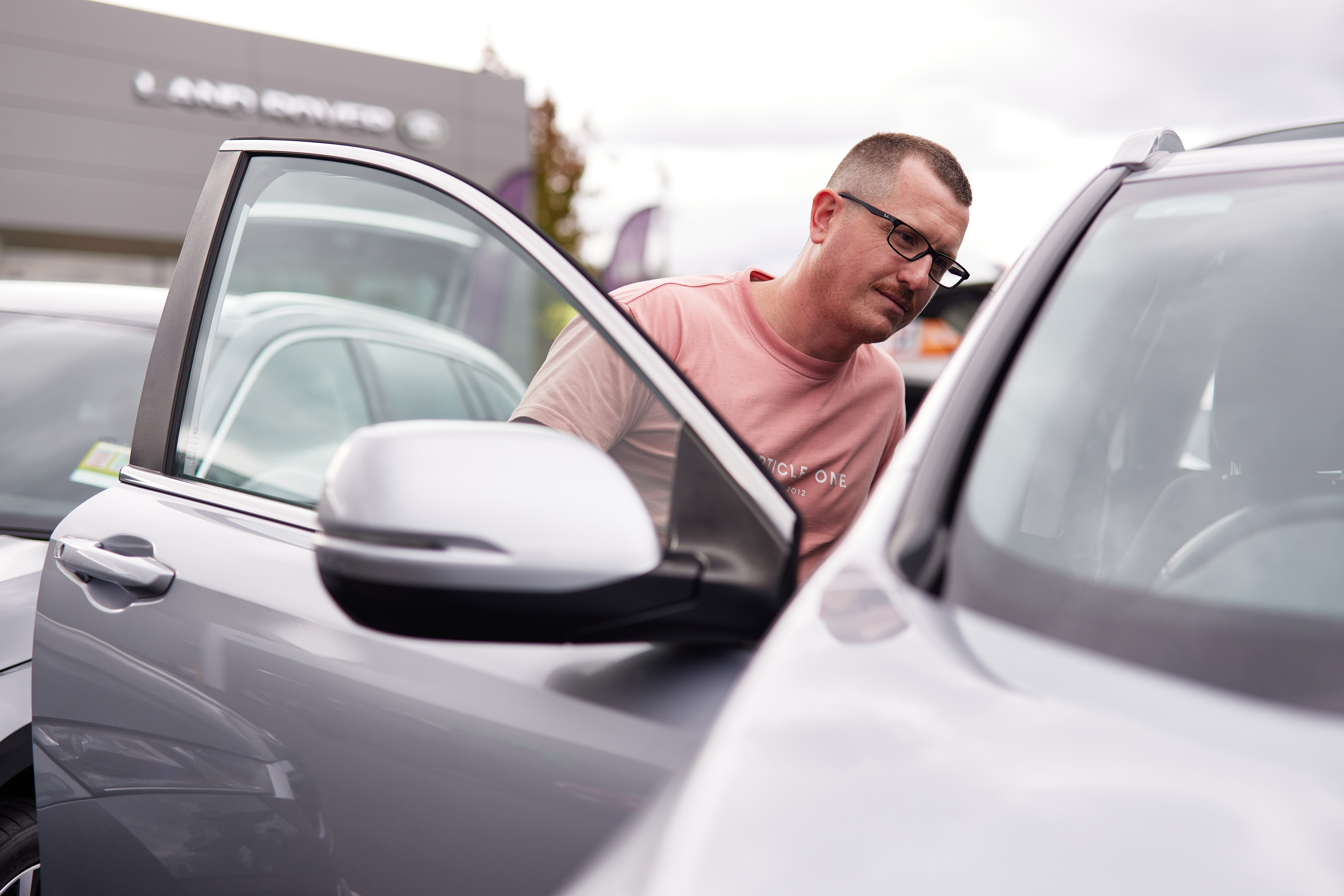 Member shopping for car and checking the inside.