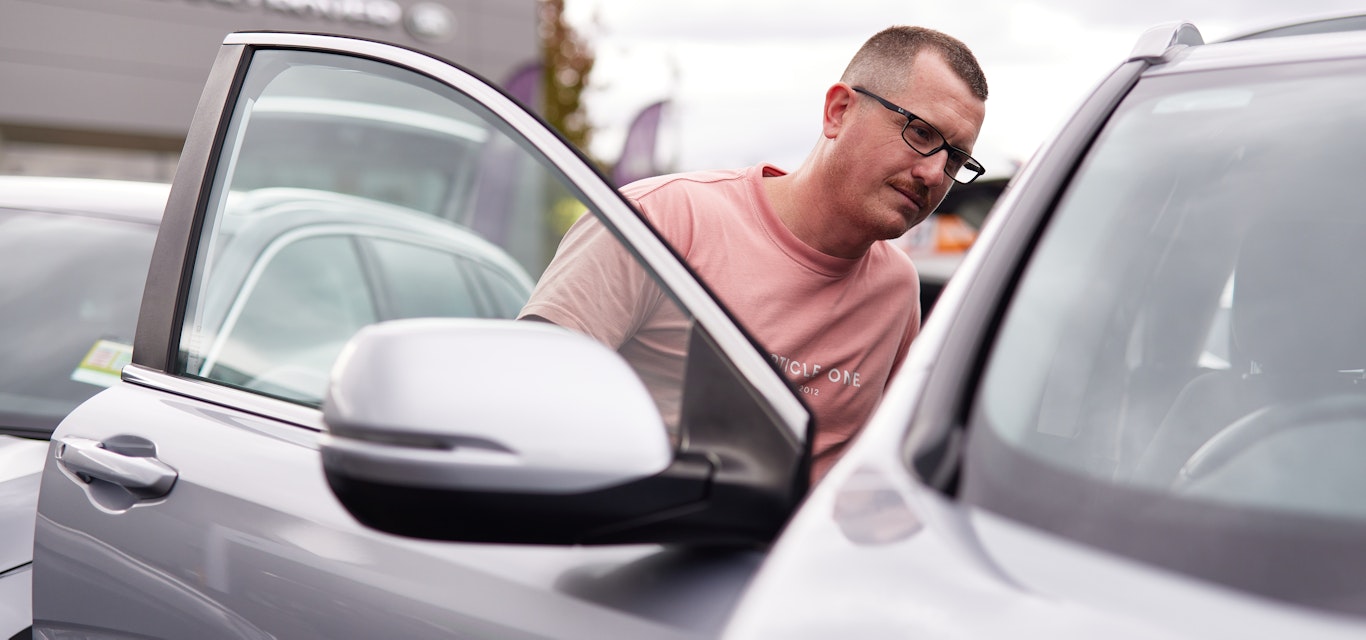 Member shopping for car and checking the inside.