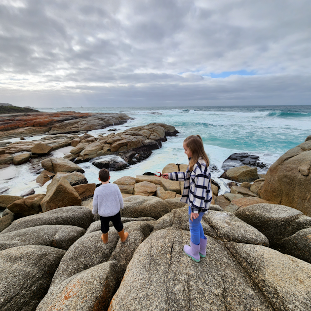 Kids exploring on rocks at the beach