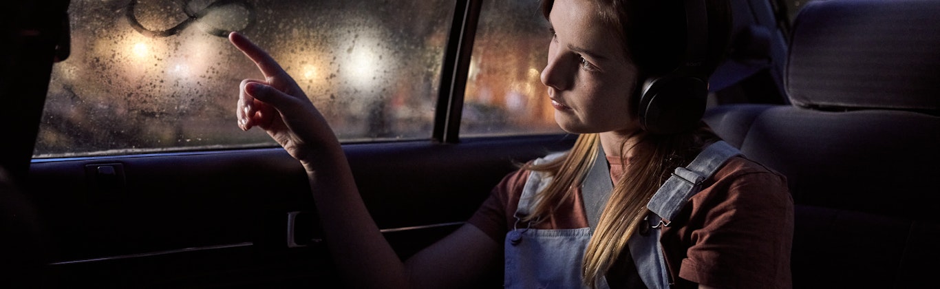 Girl in car drawing infinity logo on window