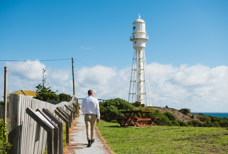 man walking towards lighthouse