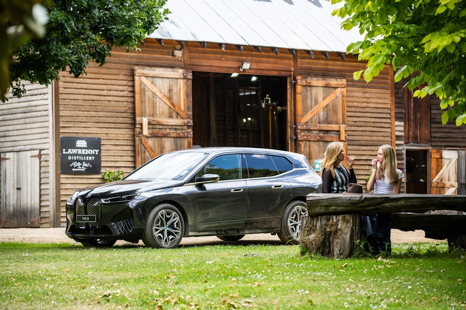 people sitting at table with car and shed in background