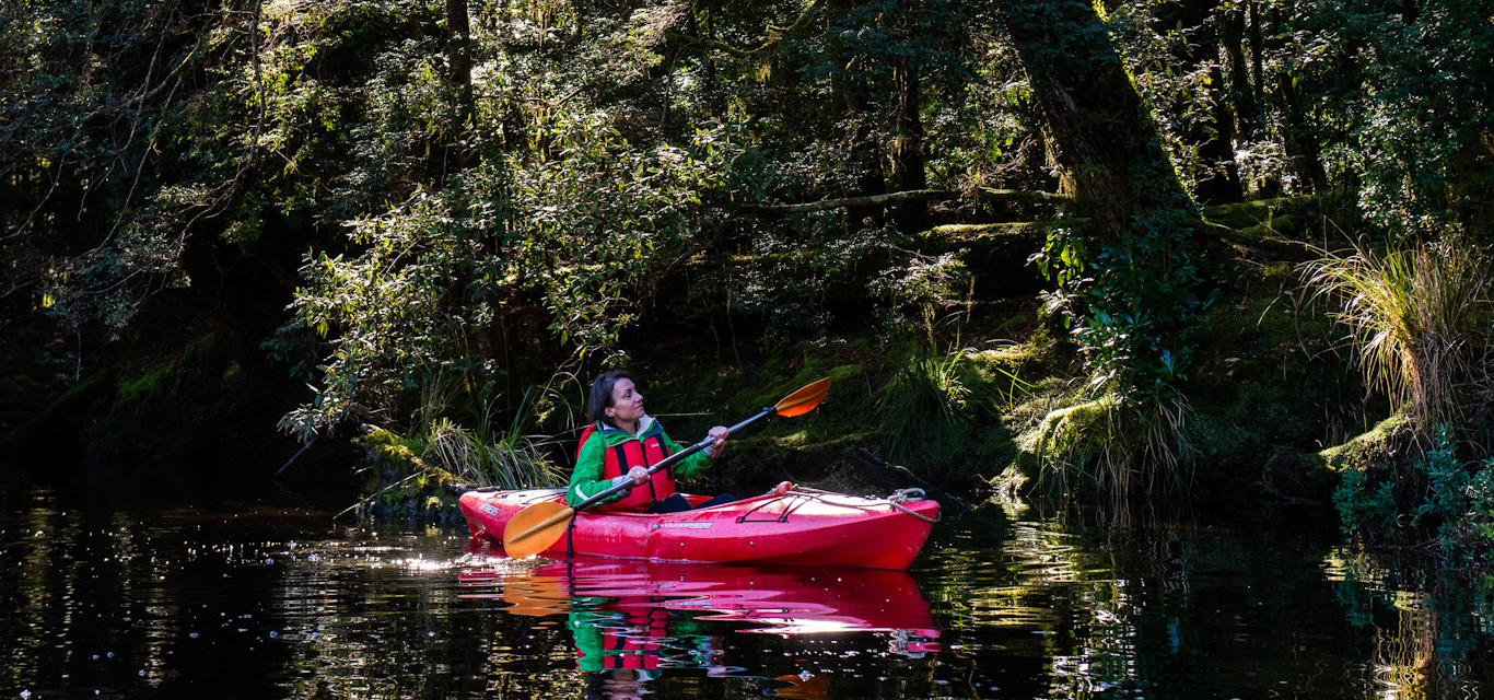 Woman kayaking down river