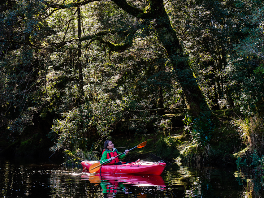 Woman kayaking down river
