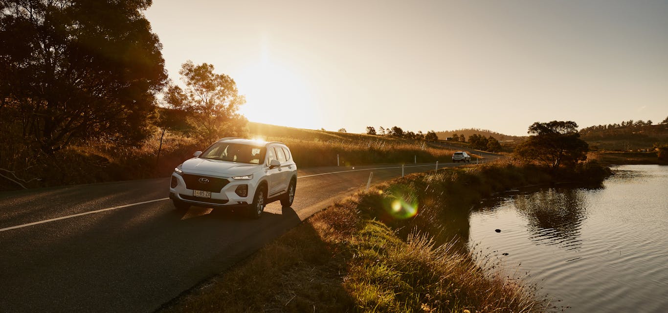 Safer driving saves fuel, too Car driving along scenic tasmanian road