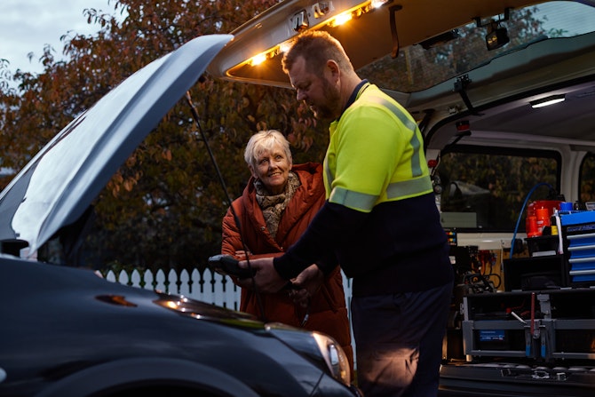 Roadside Assistance patrolman inspecting broken down car