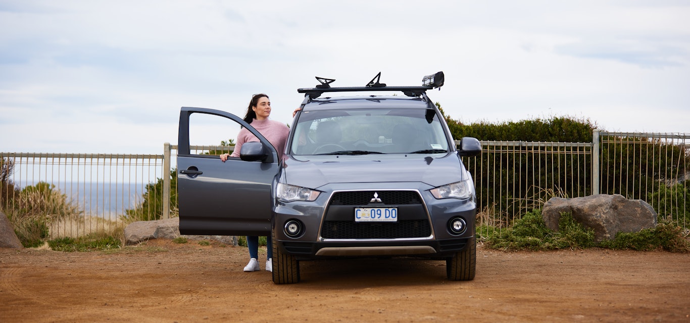 Woman at beach in car park next to her car