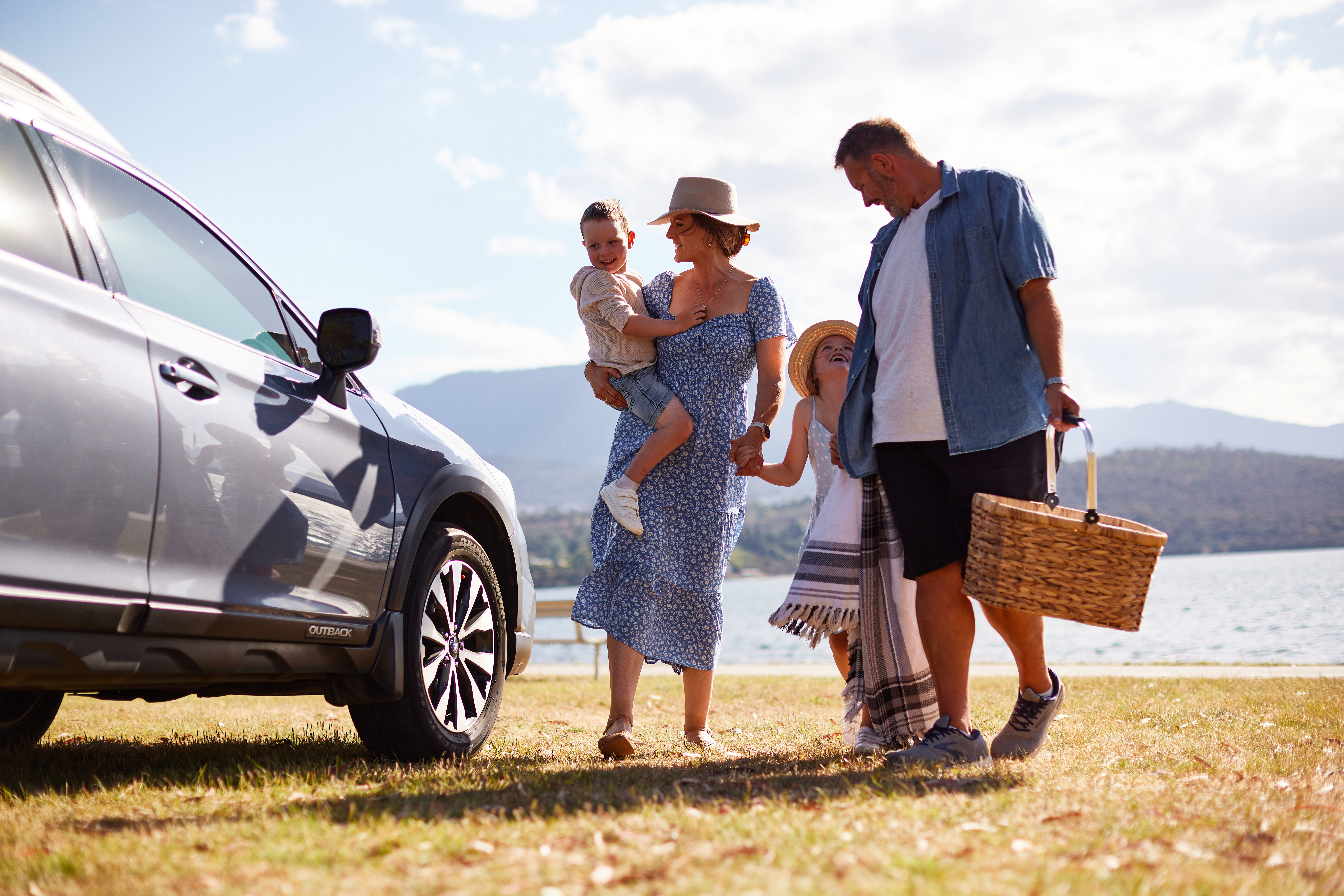 Family standing next to the car in front of the beach