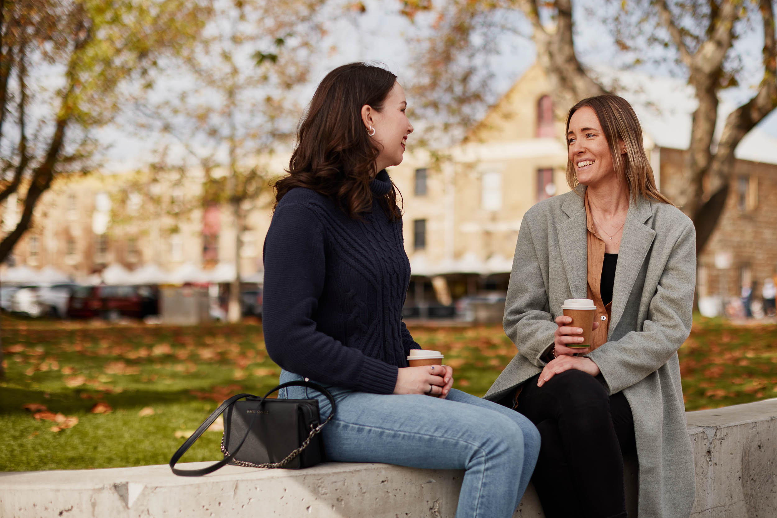 Women outside drinking take away coffee