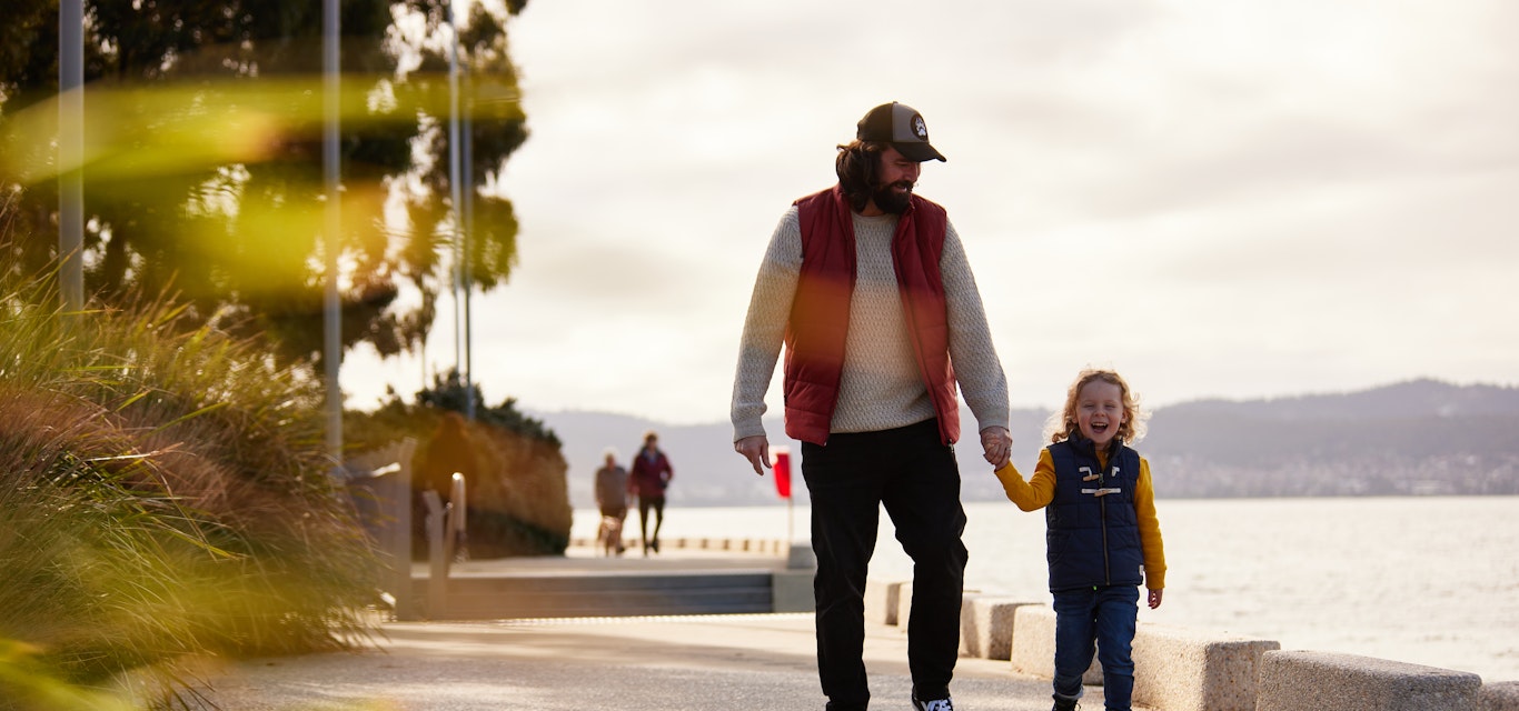 Dad walking along esplanade with son