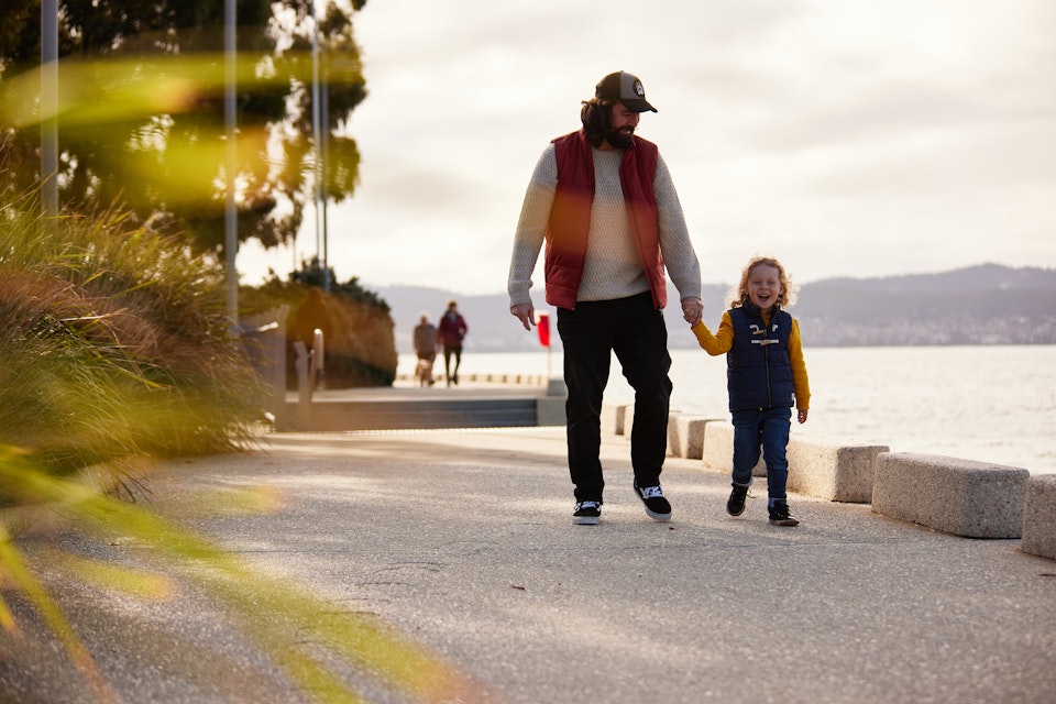 Dad walking along esplanade with son