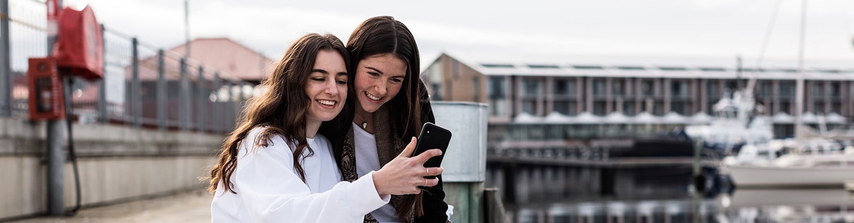 Two teenage girls looking at a mobile phone