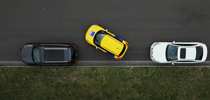 Car doing a reverse parallel park between two cars