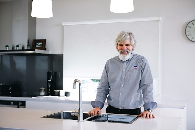 Home assessor, Malcolm, standing in the kitchen.