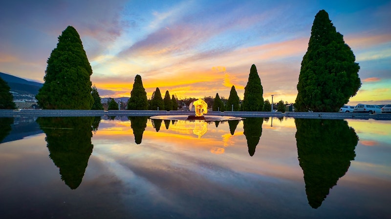 a fiery sunset at the Flame of Remembrance and Pool of Reflection in Queens Domain, Hobart