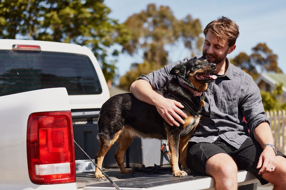 Man and dog sitting in the back of a ute