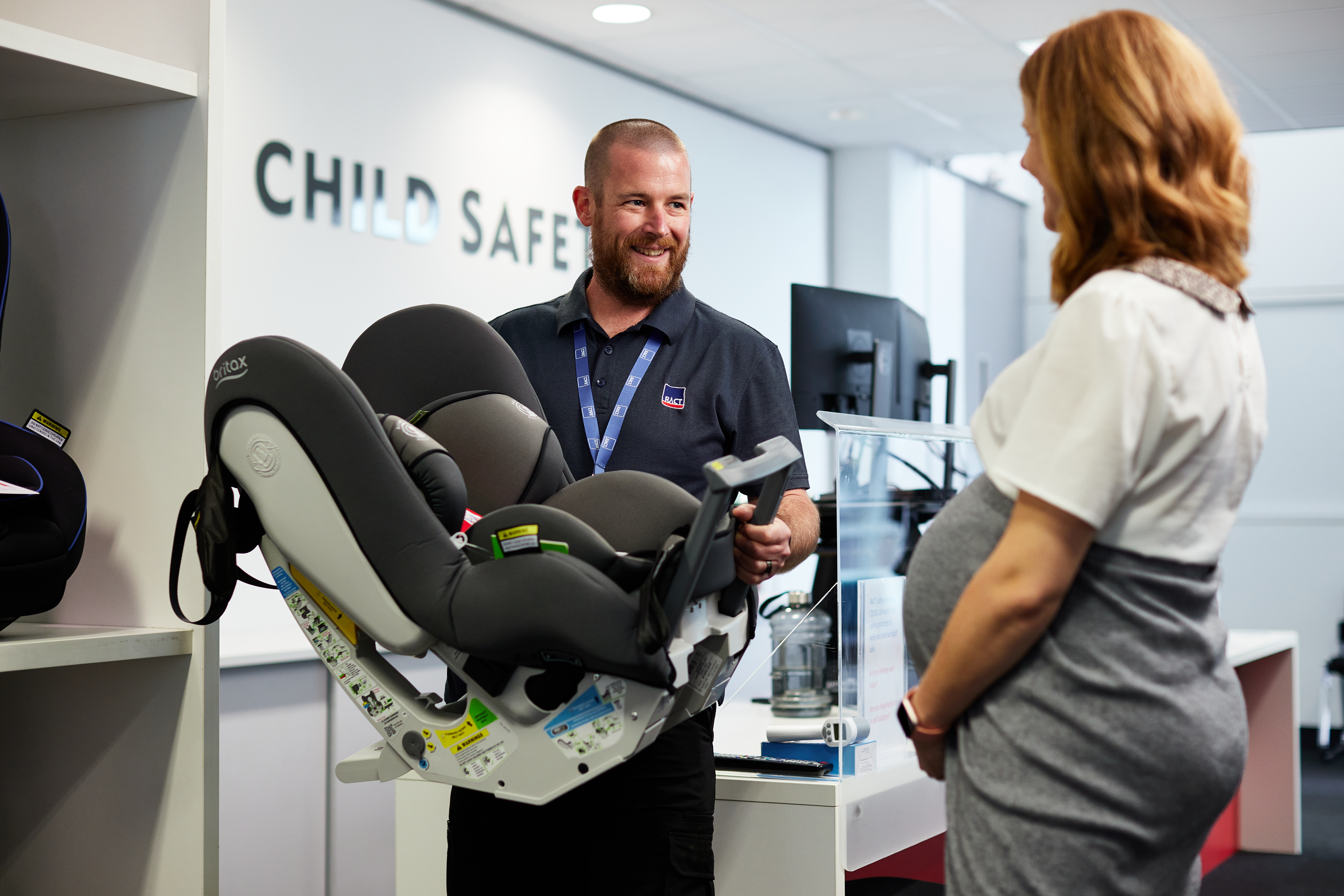 Worker holding car seat with lady
