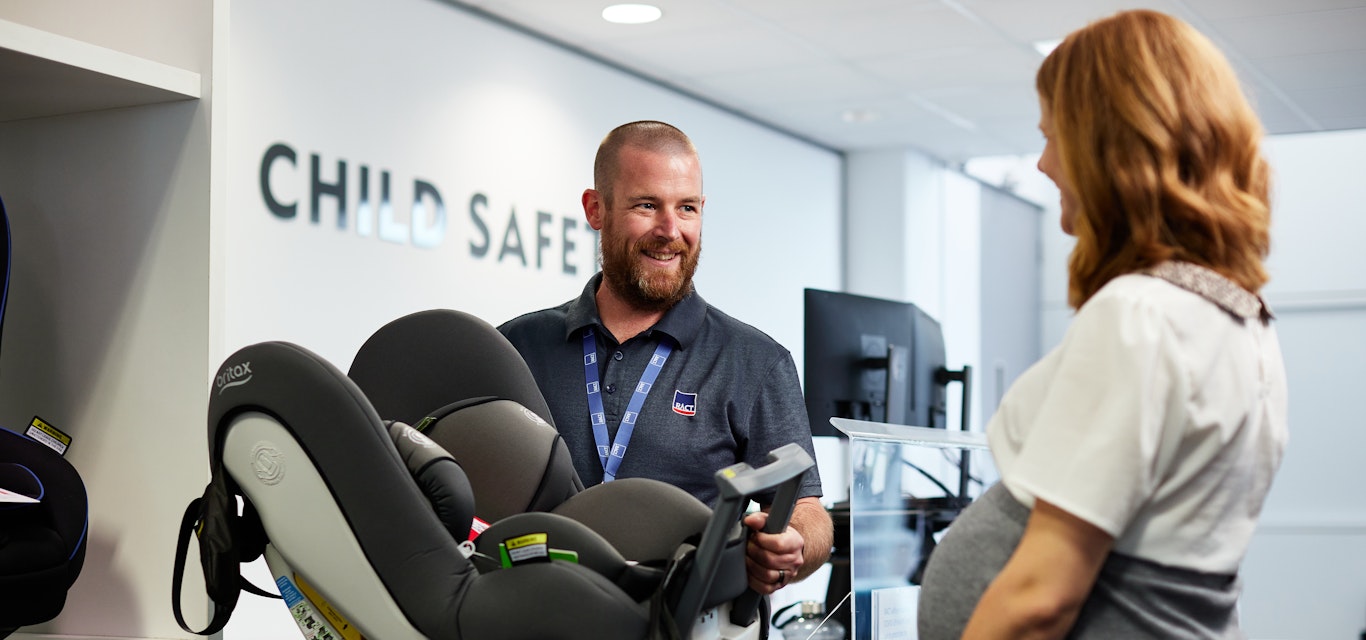 Worker holding car seat with lady