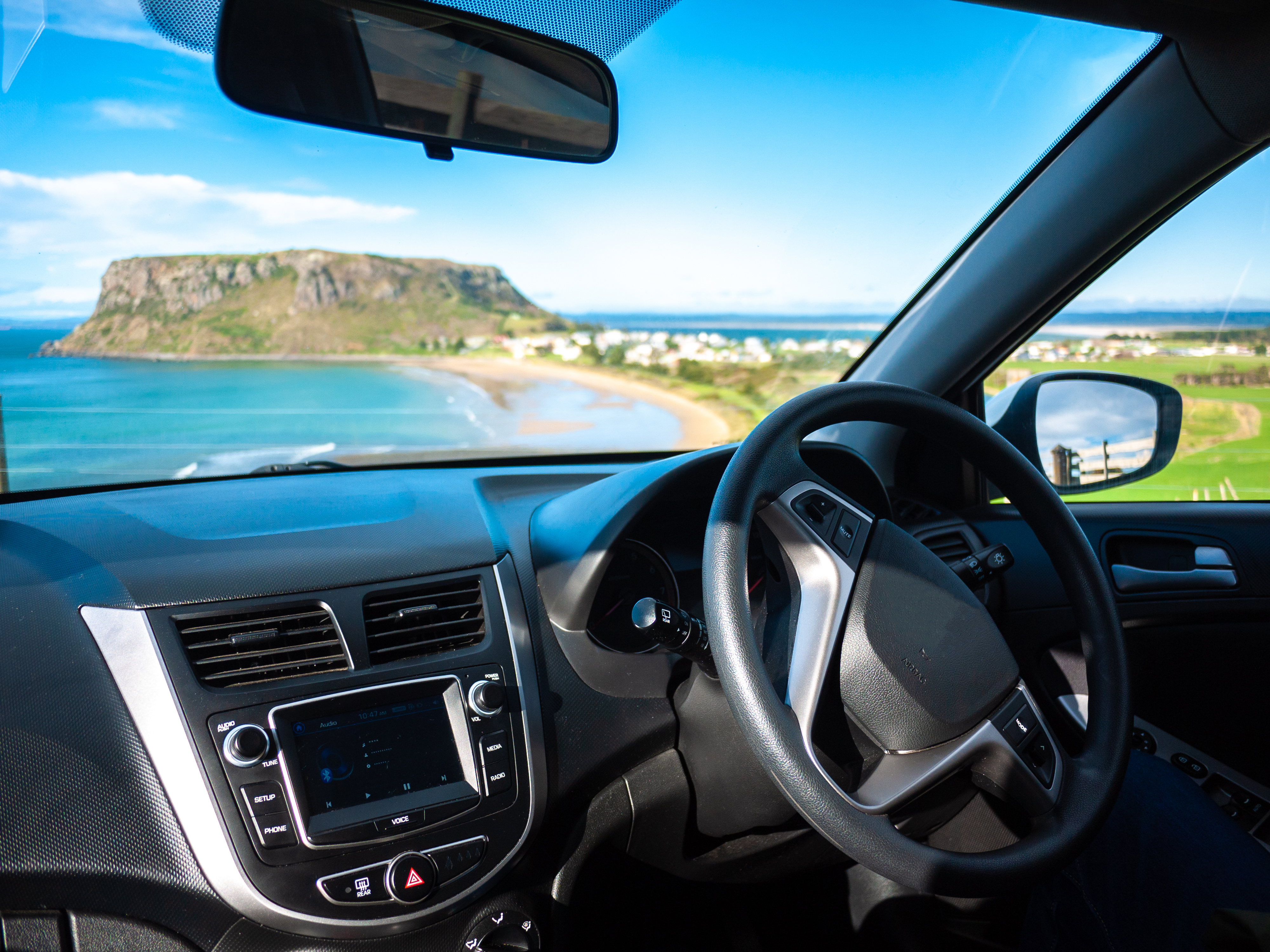 The inside of a car and looking out to the view of Tasmania