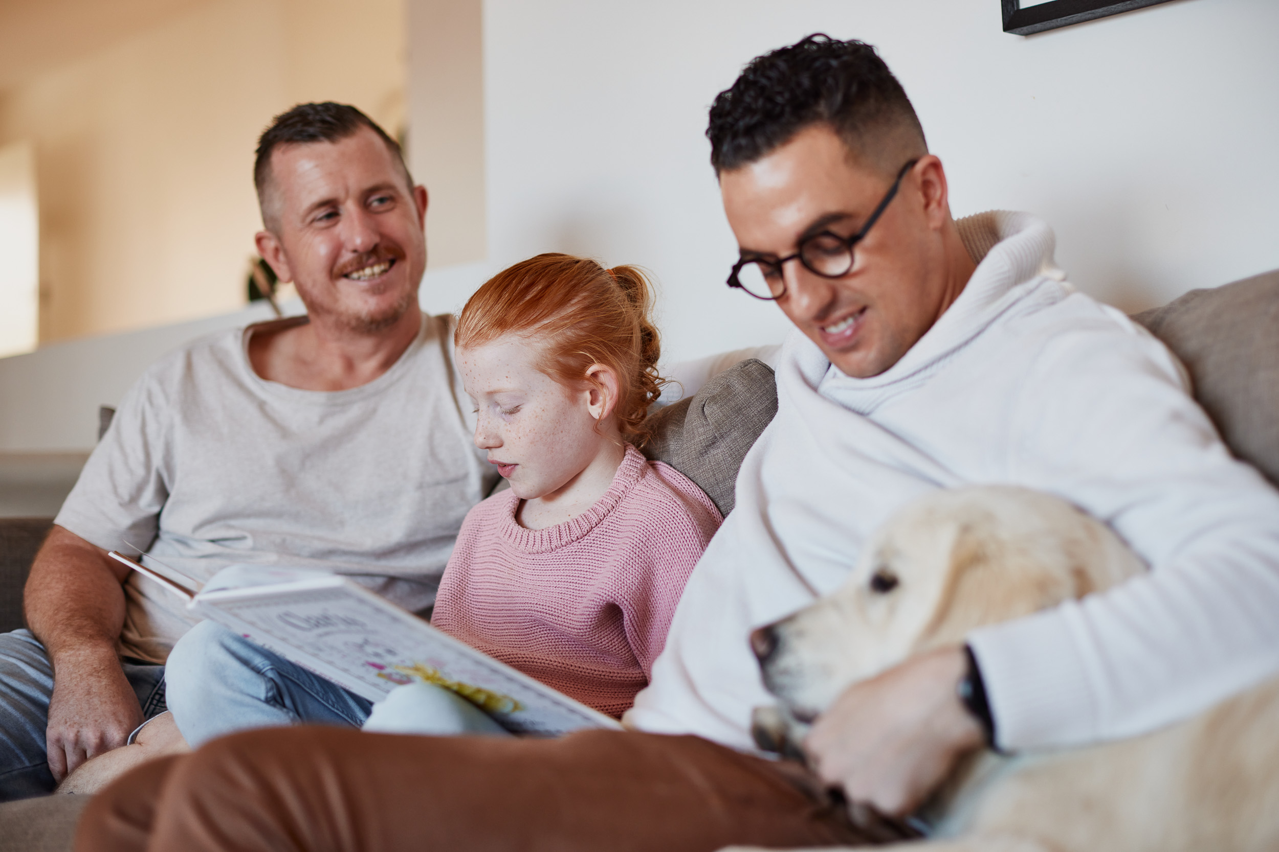 Family reading on couch with dog