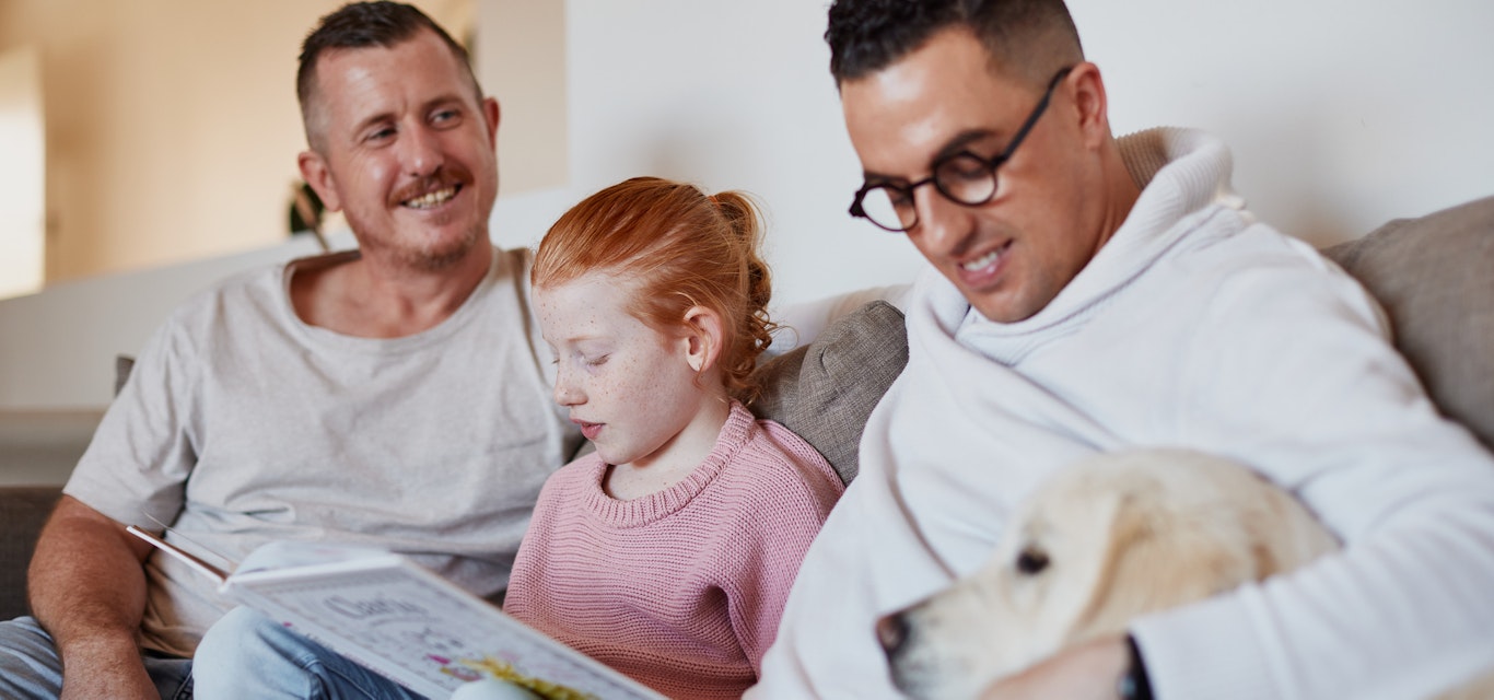Family reading on couch with dog