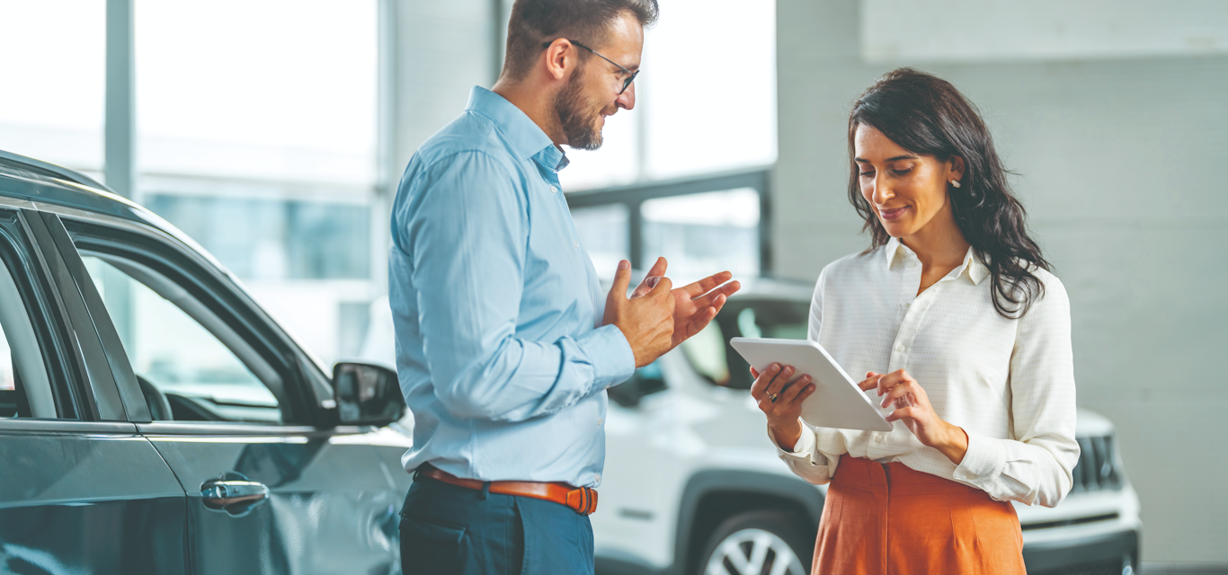 Man and woman in a car dealership