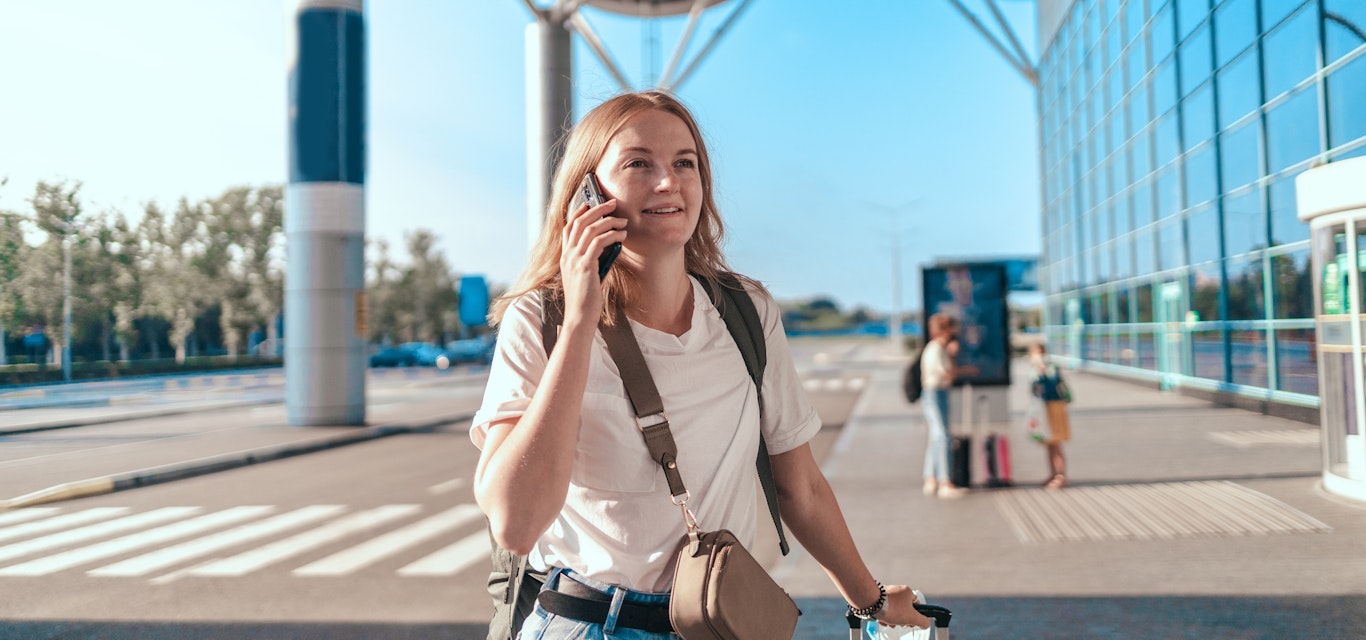 Woman on talking on the phone outside the airport
