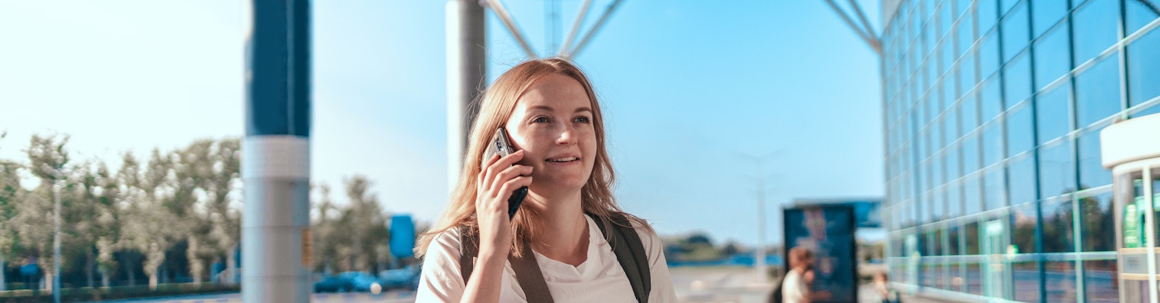 Woman on talking on the phone outside the airport