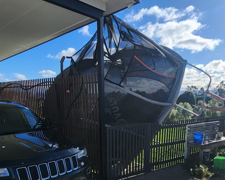 Trampoline leaning against house after strong wind storm in Tasmania