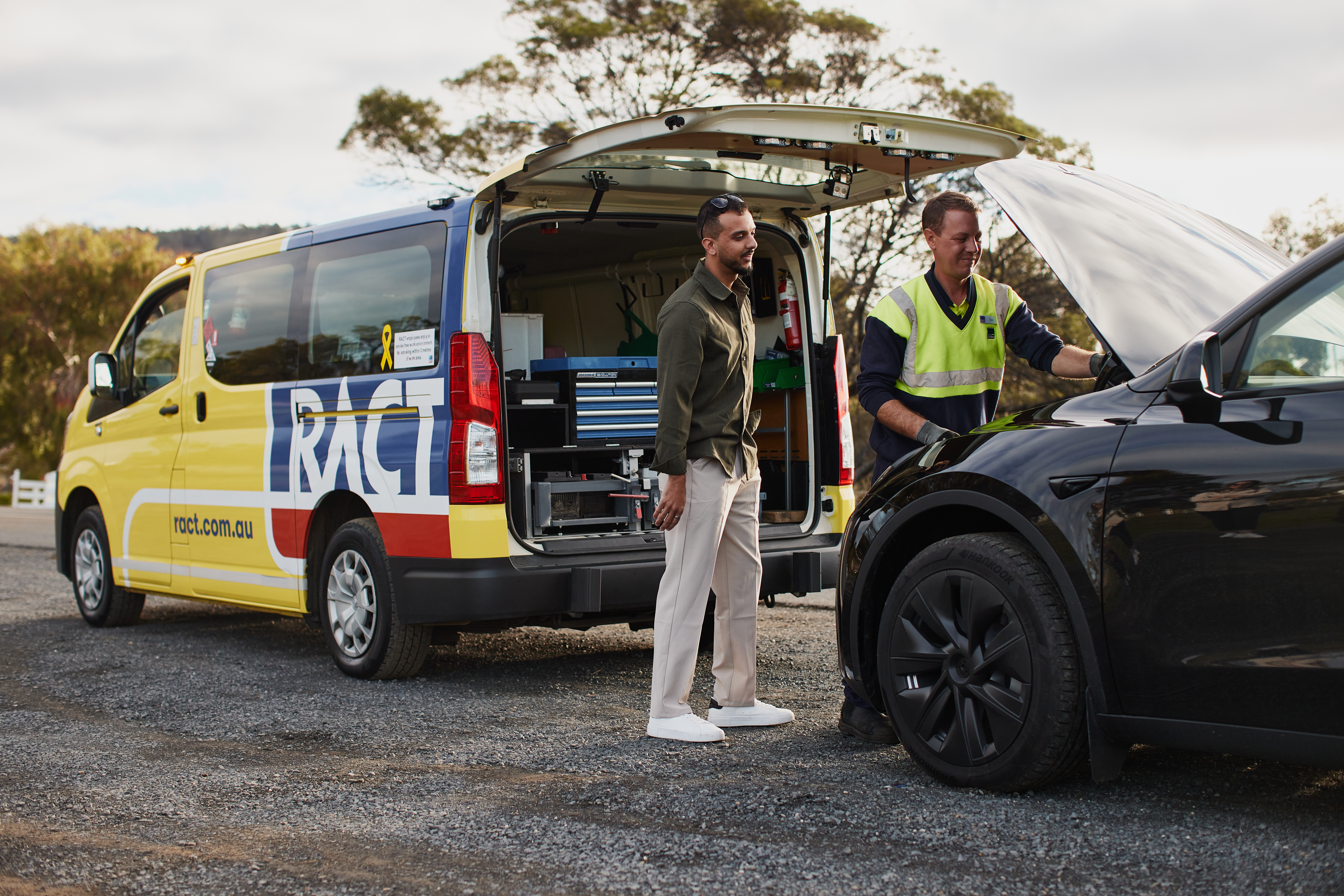 A RACT Roadside patrol man helps a member with a black car.