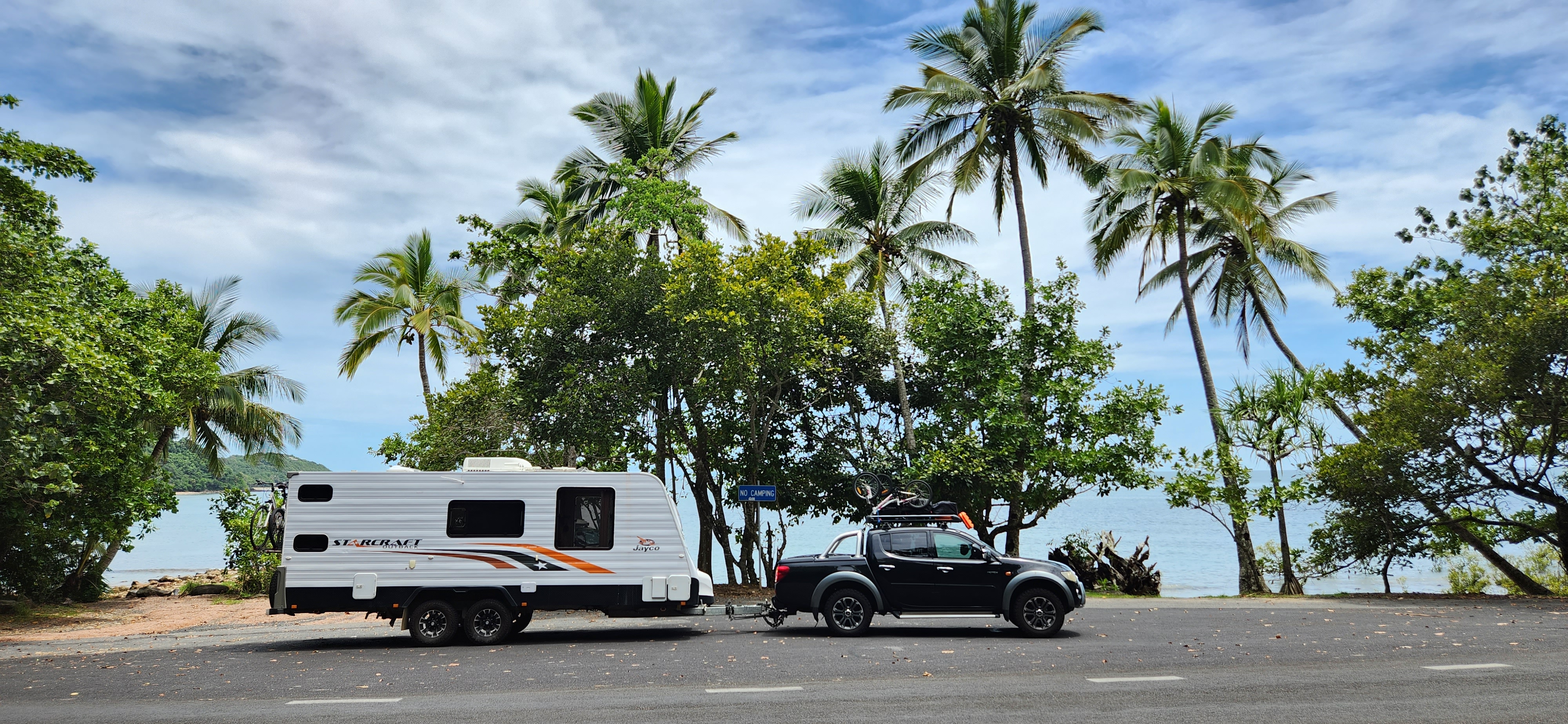Car and caravan driving along a road in Australia