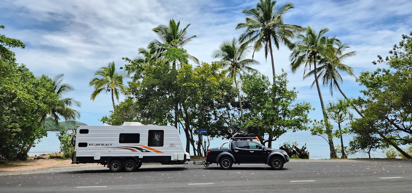 Car and caravan driving along a road in Australia
