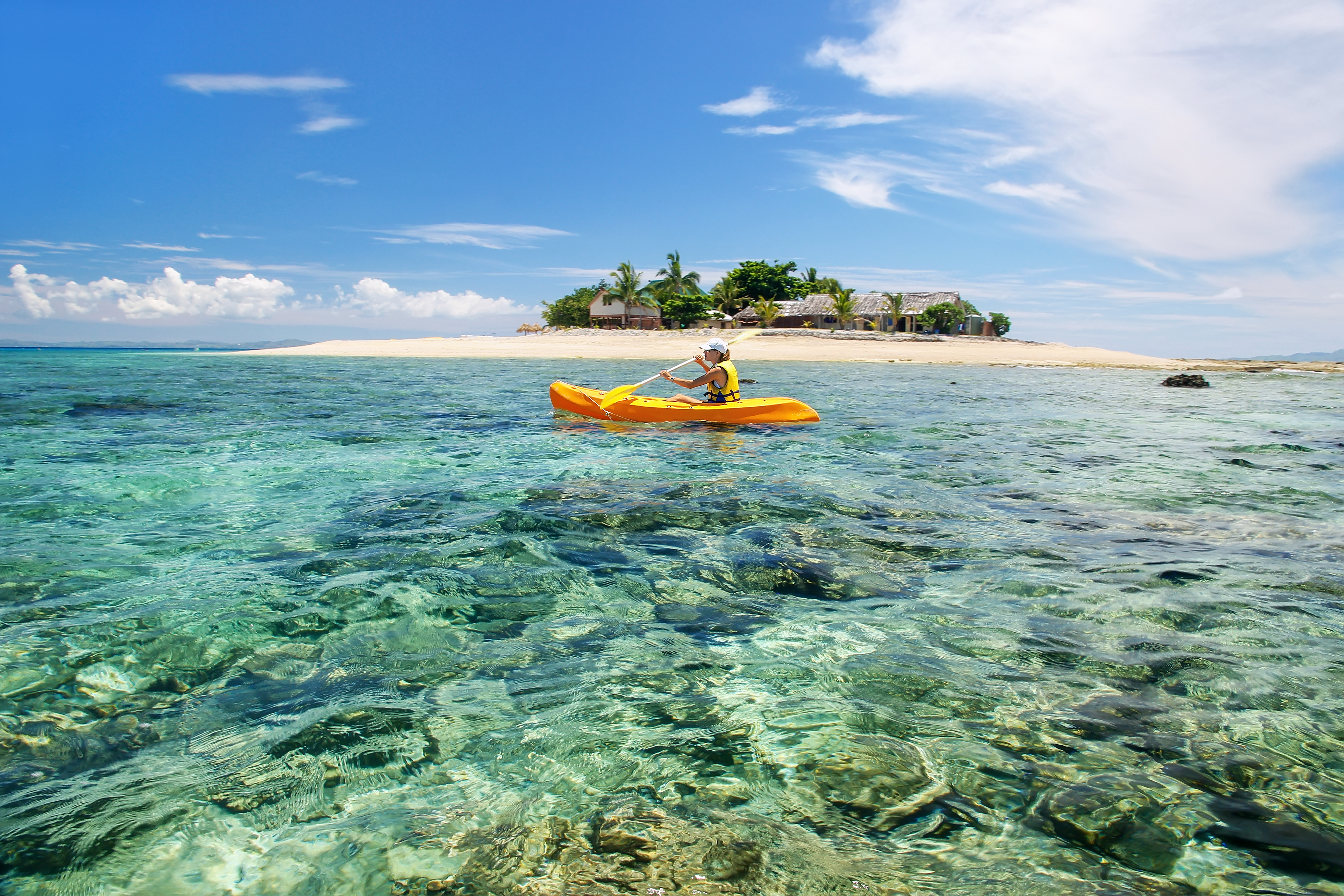 Young woman kayaking near South Sea Island, Mamanuca islands group, Fiji