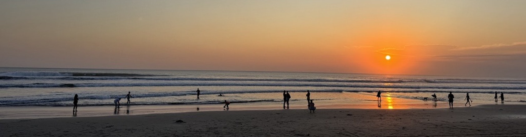 Beach in Legian, Bali at sunset People at sunset on the beach in Bali