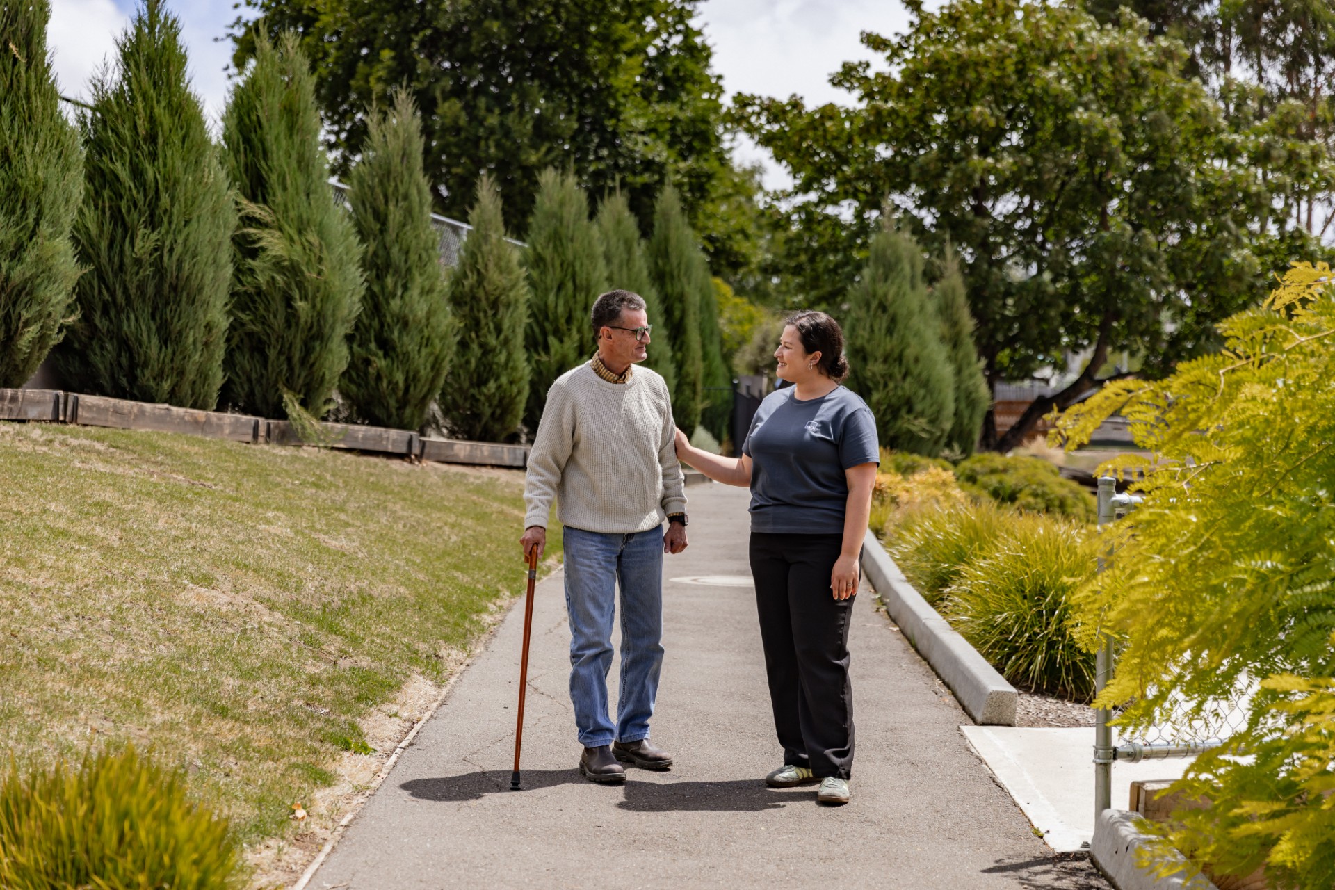 A father and adult daughter walk outside