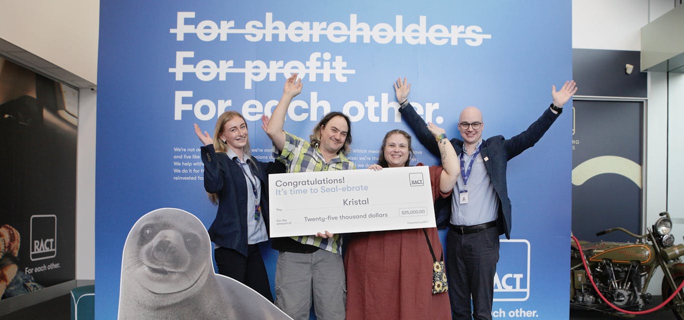 Kristal, our $25k Seal-ebrate winner Four people smile with their hands up with a novelty cheque