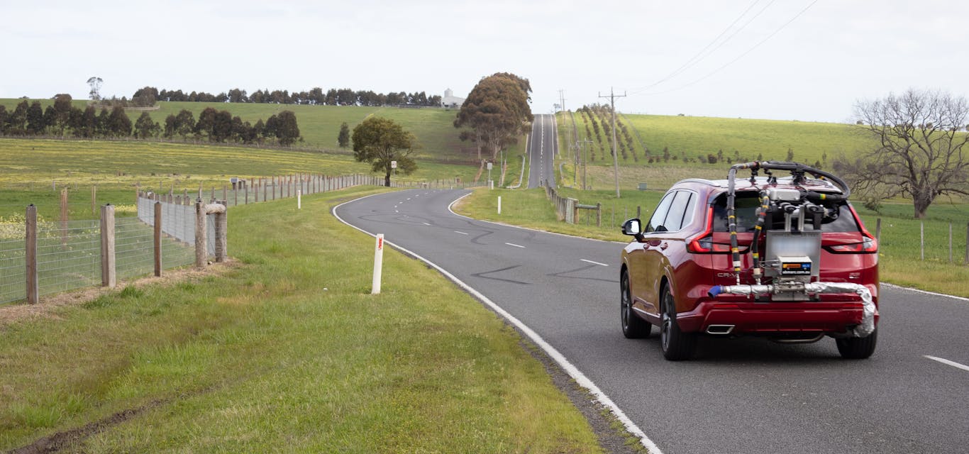 A car being tested by AAA on real roads A red car with a testing contraption drives on a rural Victorianroad