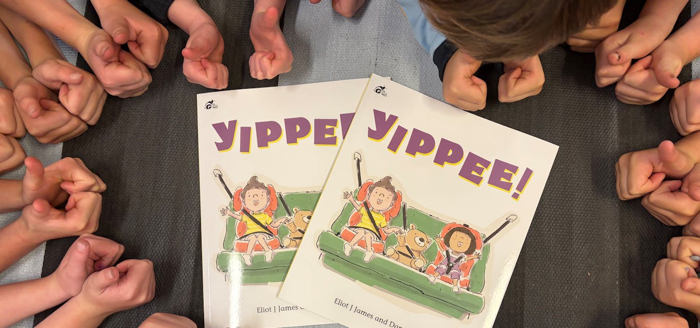 RACT'sYIPPEE! book teaches road safety to kids A circle of kids lean over the RACT YIPPEE! picture book, with their thumbs up