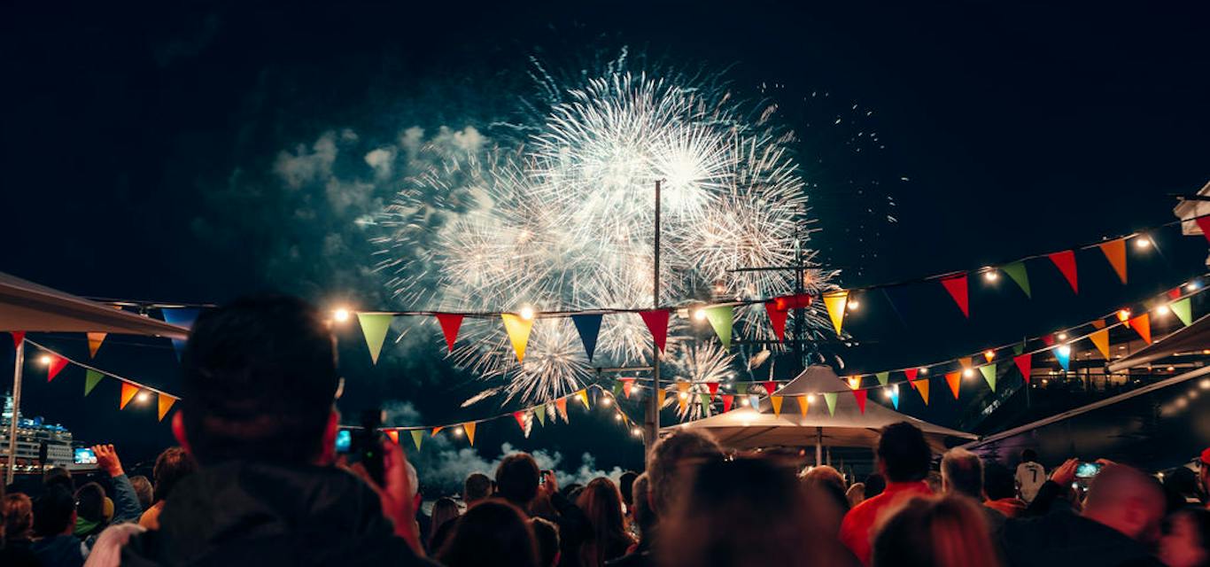 Fireworks at Taste of Summer's New Year's Eve Party A crowd look at fireworks in the sky, with rainbow bunting