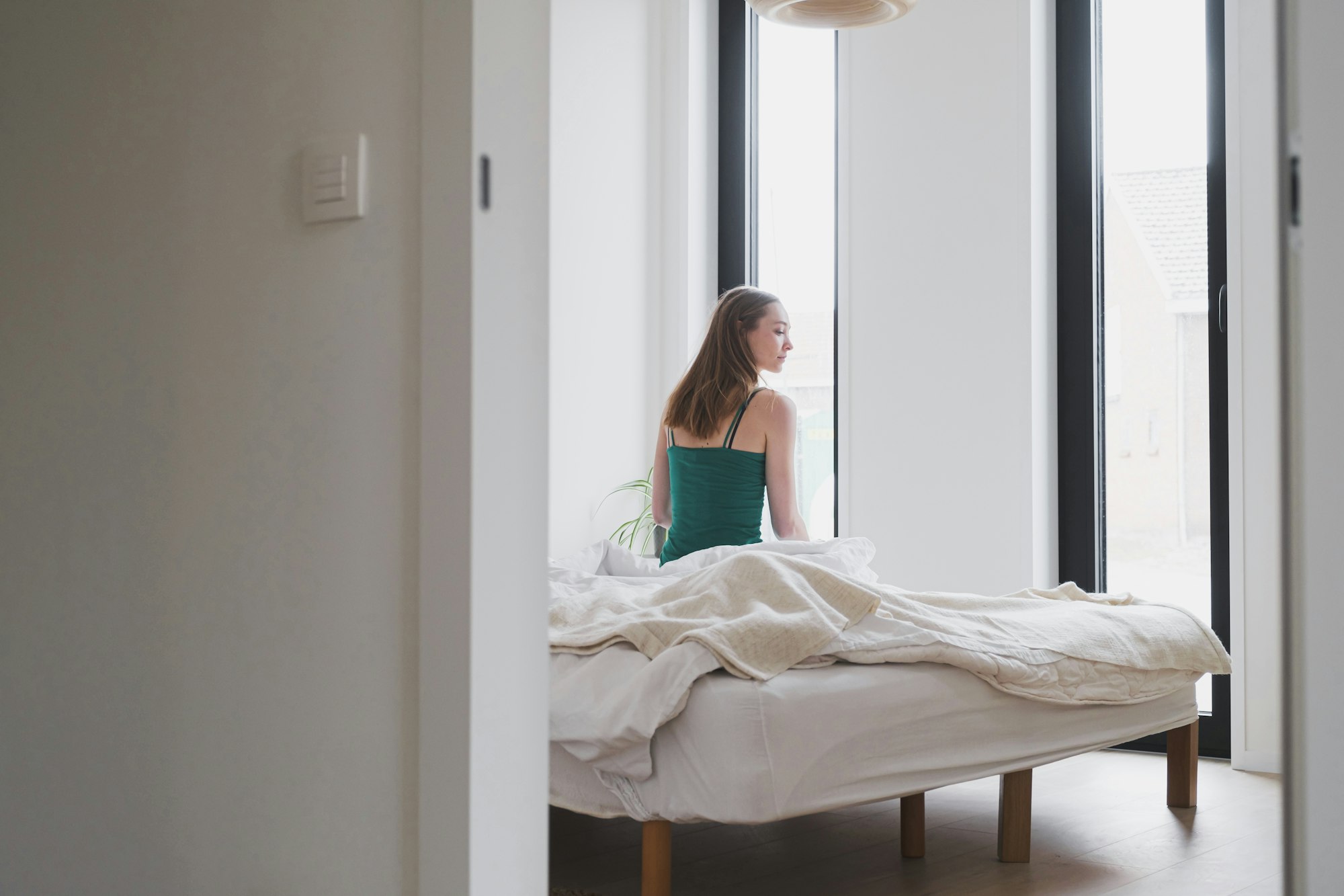 Jonge vrouw zit op een bed in slaapkamer van een Skilpod