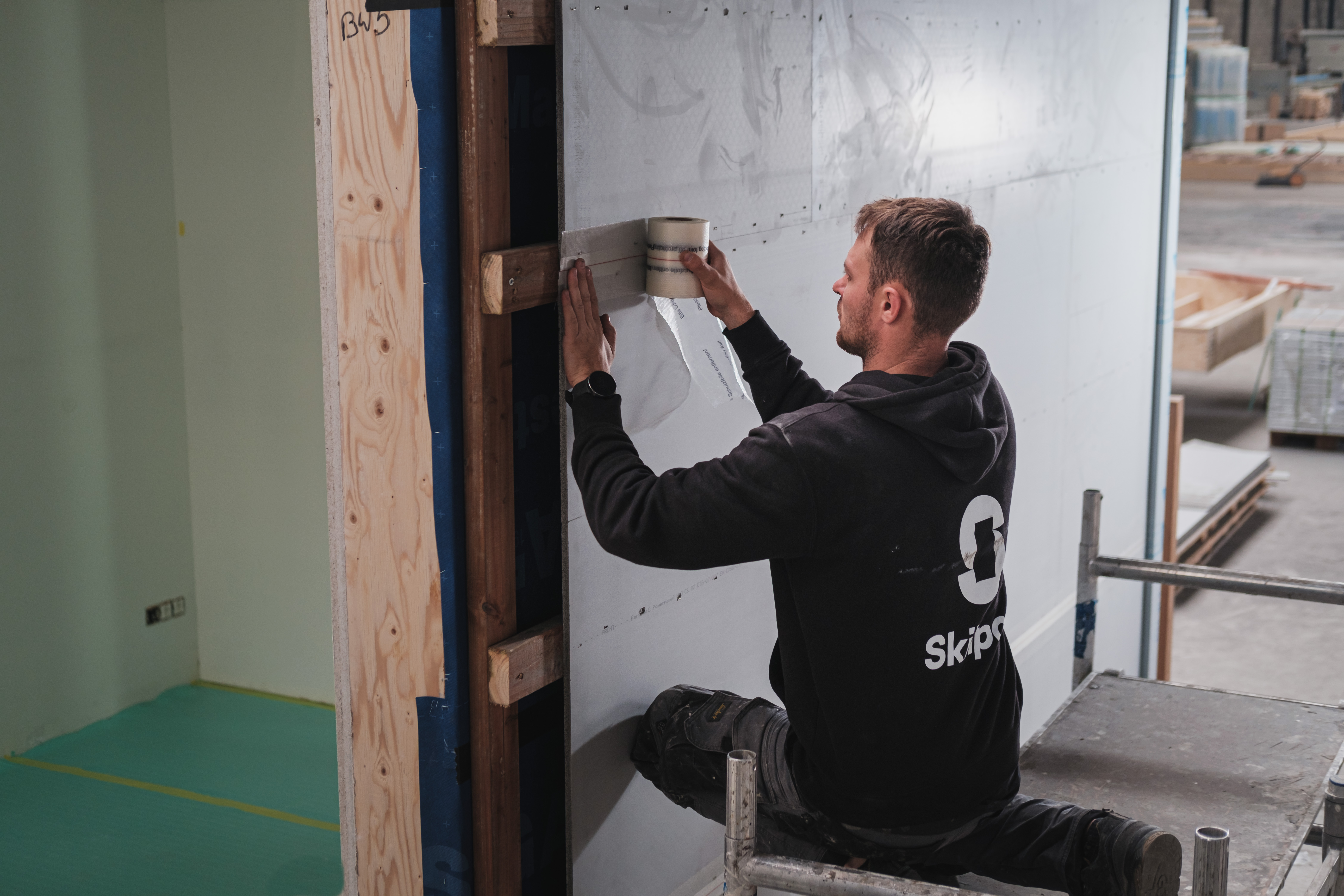 Vakman werkt aan de wand van een houtskeletbouw module