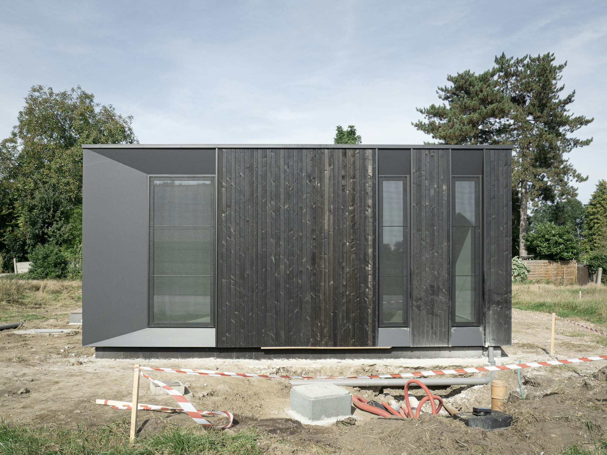 Houtskeletbouw woning Skilpod #100 in zwart hout, recent geplaatst op de bouwwerf