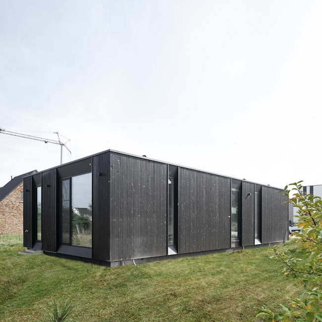 Houtskeletbouw woning Skilpod #100 in zwart hout, zicht op de achterkant van het huis in zwart hout
