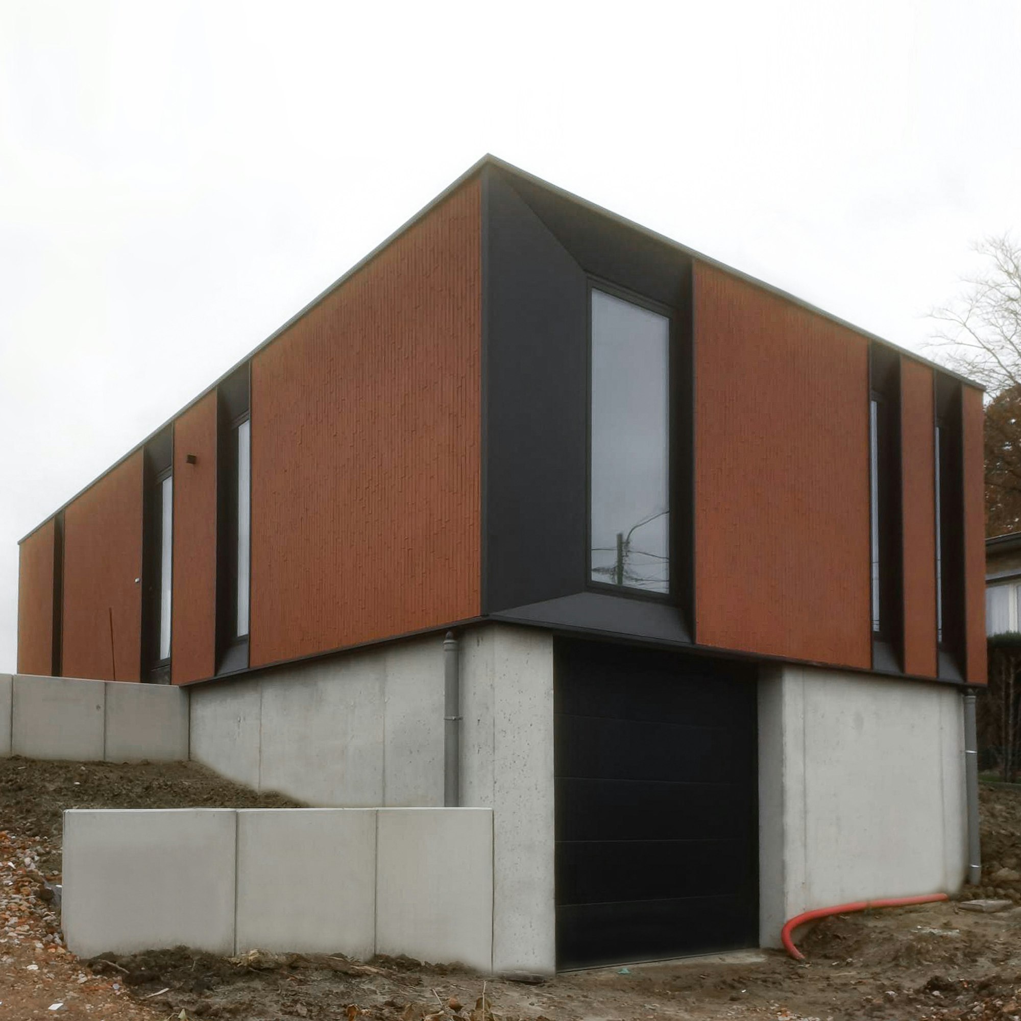 Houtskeletbouw woning Skilpod #100 op kelder met garage, modern design afgewerkt met rode steen